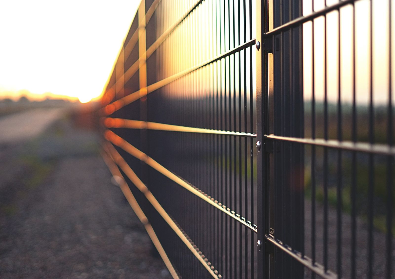 Moderner Metallzaun im Abendlicht entlang eines Grundstücks